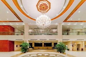 A spacious lobby with a grand chandelier, multiple floors, and a central seating area. - Xinyu Donghu Four Seasons Hotel (Xinyu)