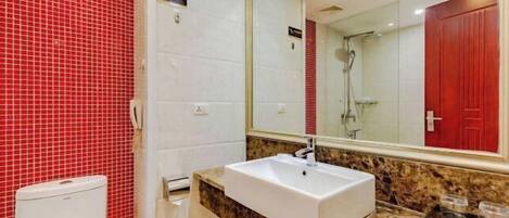 A bathroom with a white sink, red tiled walls, and a large mirror.