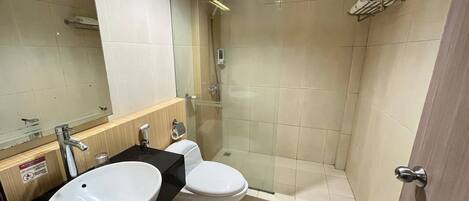 A modern bathroom with a sink, toilet, and glass-enclosed shower.