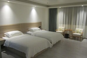 A hotel room with two beds, a wooden headboard, a large window with curtains, and two chairs. - AN Hotel (Haifeng)