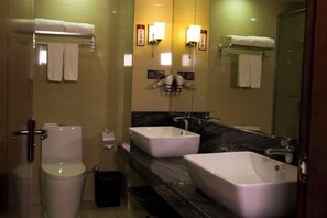 A bathroom with two sinks, a toilet, and a shower.