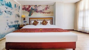 Una habitación de hotel con una cama grande, un mural en la pared y una ventana con cortinas.