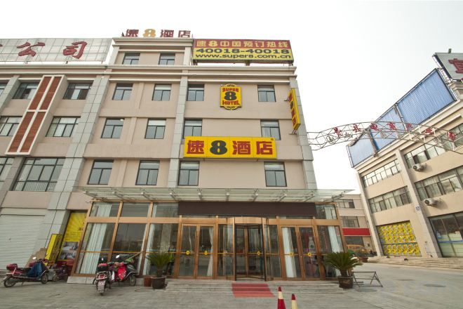 A hotel with a prominent sign, multiple floors, and a large entrance.
