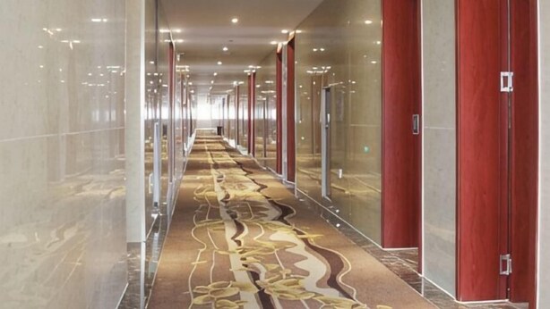 A long, narrow hallway with mirrored walls, a patterned carpet, and red doors. - Super 8 Feixian New Bus Station Yinyuan Jiaju Square (Fei County)