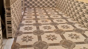 A tiled corridor with a patterned floor and walls, leading to a doorway. - Appartement de 150m2 Proche Dune Belle Plage (Marsa Ben M'Hidi)