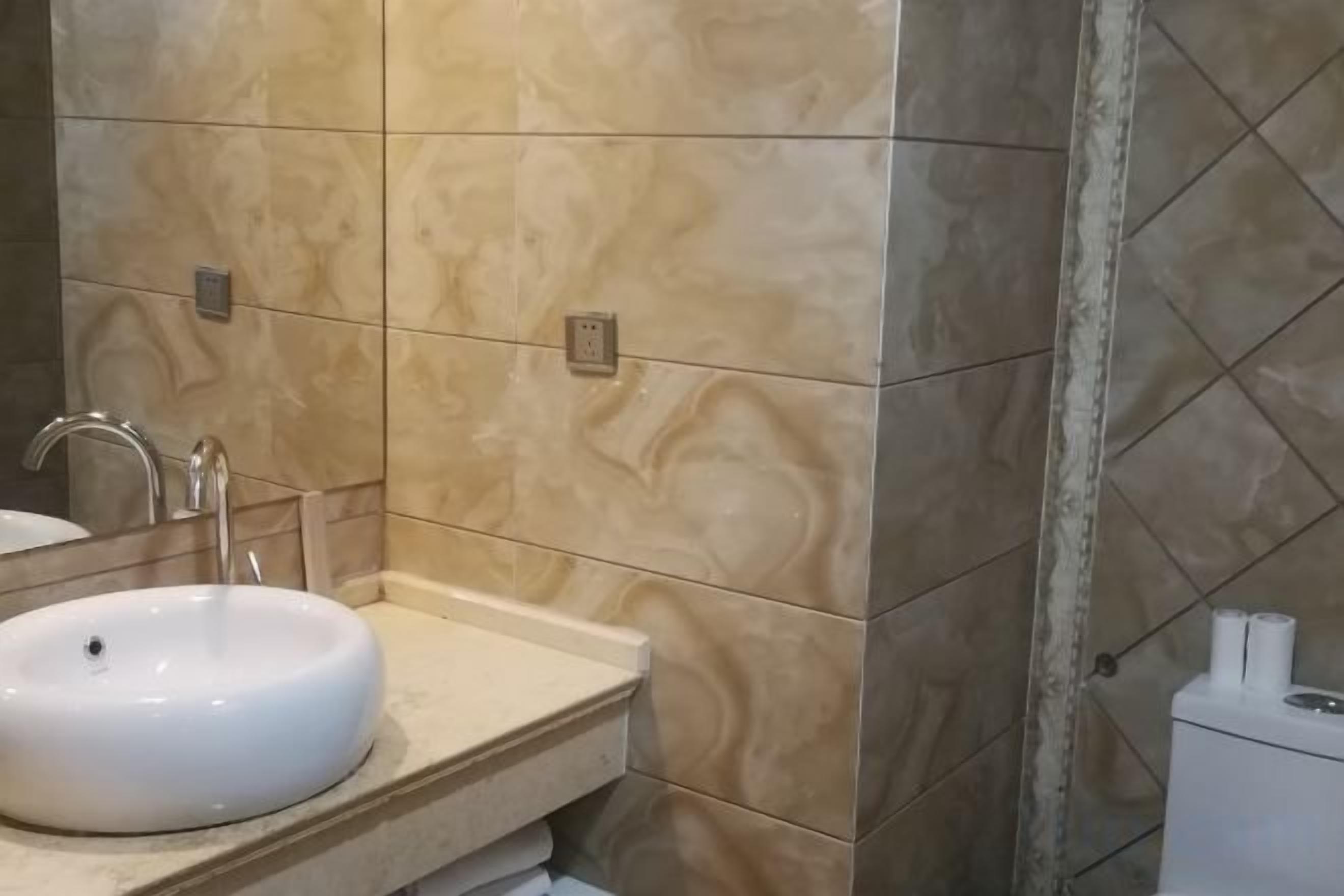 A bathroom with a sink, mirror, and toilet.