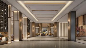 Un hall d’entrée spacieux, doté d’un comptoir d’accueil central, d’un éclairage moderne et d’un design épuré et minimaliste.