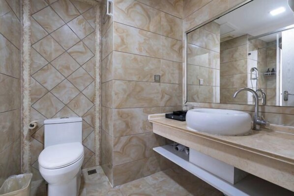 A bathroom with a toilet, sink, and shower.