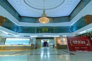 A spacious lobby with a high ceiling, a central chandelier, and a reception desk. - Shimao Tuke China Hotel wuhu (Wuhu)