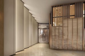 A hallway with sliding doors and a traditional wooden screen.