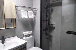 A modern bathroom with a sink, mirror, towel rack, shower, and toilet. - MY FAMILY HOTLE (Yueqing)