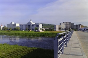 A riverside walkway with a modern building complex in the background. - Yichun Wengxinyuan Family Guesthouse (Tangwang County)