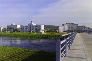 Un paseo fluvial con un complejo de edificios modernos al fondo.