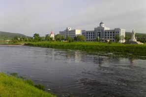 A river with a building and statue in the background.