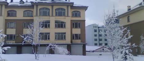 A multi-story building with a symmetrical facade, large windows, and a flat roof.