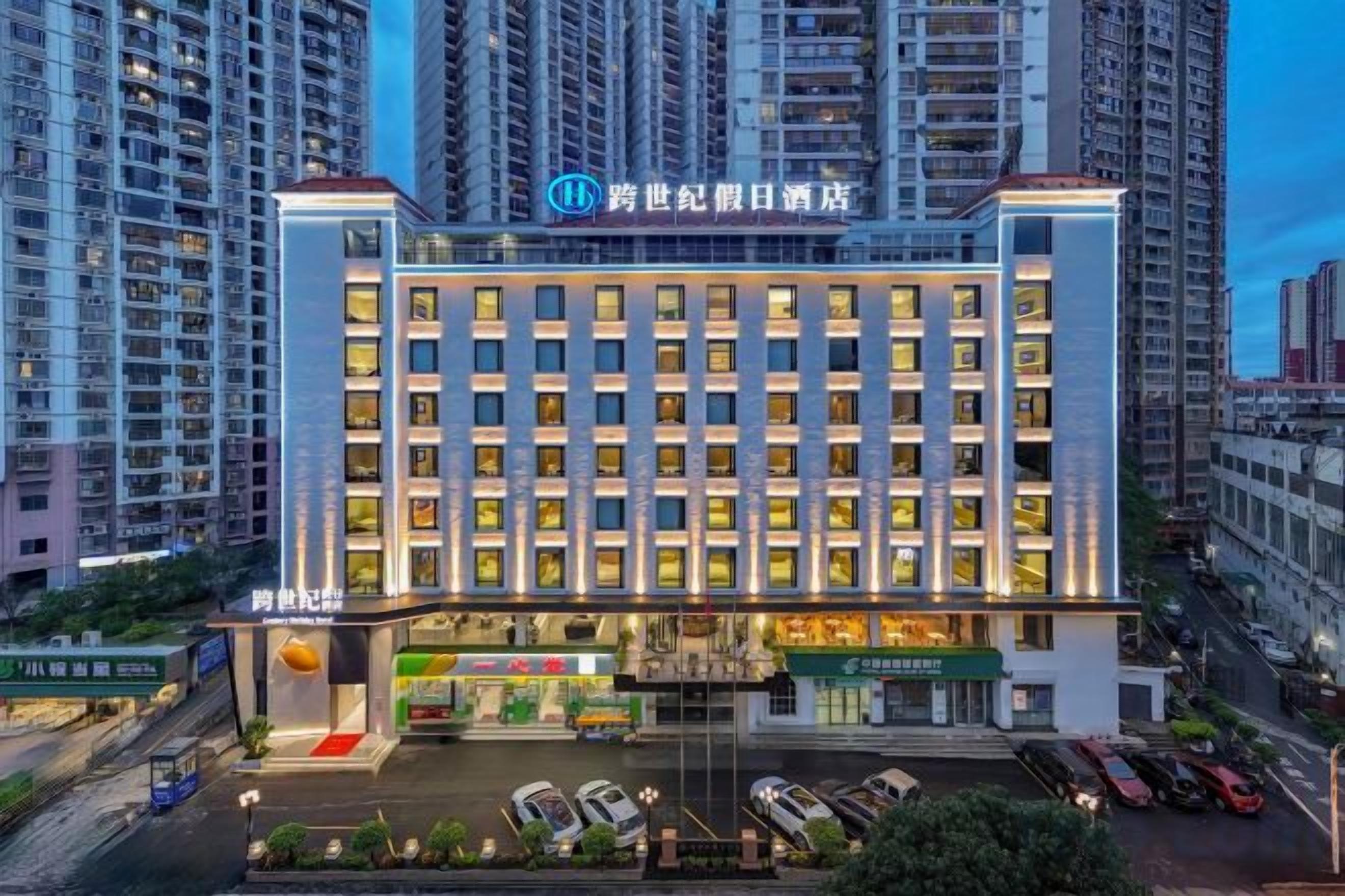 Un hôtel à plusieurs étages, doté d’une entrée imposante, d’un parking et offrant une vue sur les immeubles environnants.
