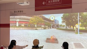 A projection of a fire station with a fire prevention hero station sign and an evacuation experience line sign. - Beitou Resort Metro Inn (Taipei)