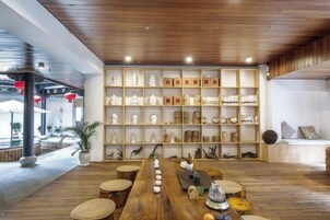 Un comedor de madera con una mesa larga, rodeada de estanterías con diversos objetos decorativos.