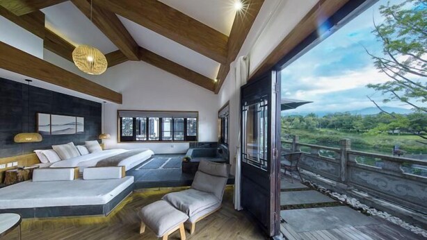 A modern interior with a large window, wooden beams, and a seating area. - Yunyi Hot Spring Zangpin Inn (Tengchong)