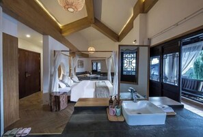 Un dormitorio moderno con una cama grande, una mesita de noche, un espejo y vistas al exterior.