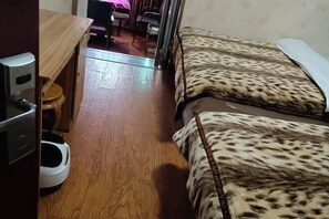 A room with a bed, a small wooden table, a chair, and a toilet. - Bazhong city home business hotel (Bazhong)