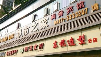 A building with signage indicating it is a commercial property, possibly a hotel or office space, with contact information and a business name visible.
