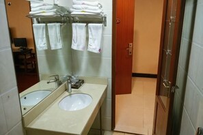 A bathroom with two sinks, a mirror, and a towel rack with towels. - Xingyi Satisfaction 168 Hotel (Xingyi)