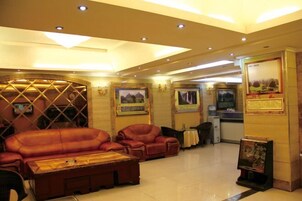 Un hall con sofás de cuero, una mesa de centro y un mostrador de recepción.