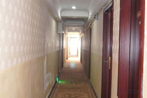A hallway with patterned walls, a carpeted floor, and wooden doors. - Xingyi Satisfaction 168 Hotel (Xingyi)