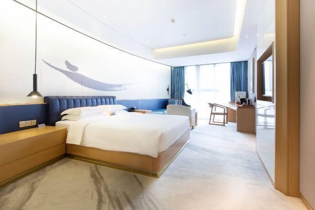 Une chambre d’hôtel moderne, dotée d’un grand lit, d’un bureau et d’un coin salon.
