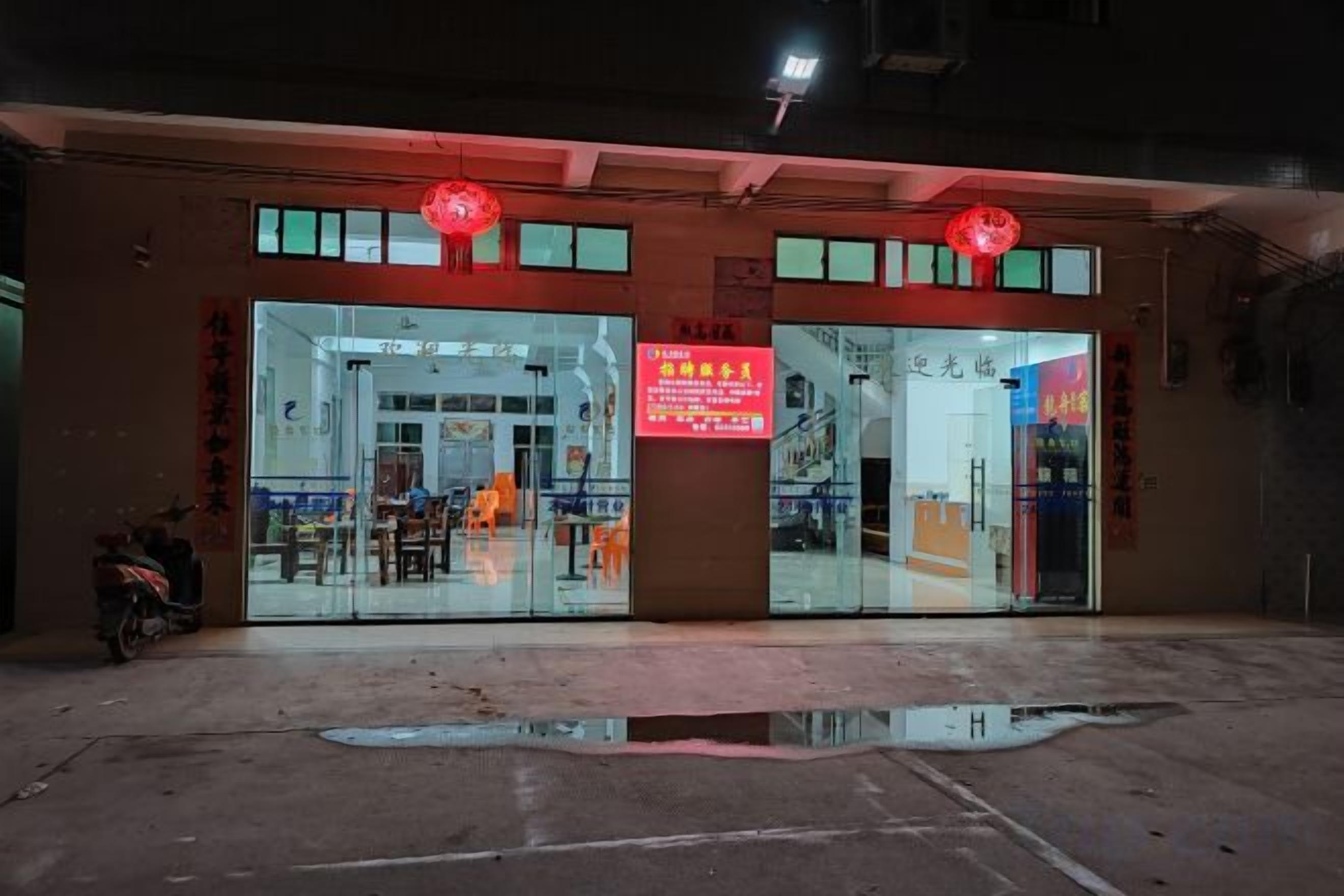 A building with a glass storefront and a red sign.
