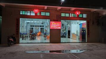 A building with a glass storefront and a red sign.