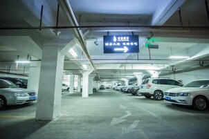 Un aparcamiento subterráneo de varios niveles con señales direccionales y un letrero de salida verde.