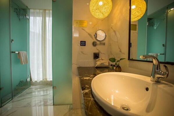 Un baño con un lavamanos grande, un espejo y dos lámparas colgantes.