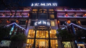 Un hotel con fachada moderna, señalización iluminada y una entrada destacada con puertas de vidrio.