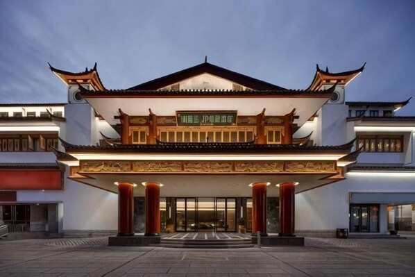 A traditional building with a prominent entrance, large columns, and a signboard.
