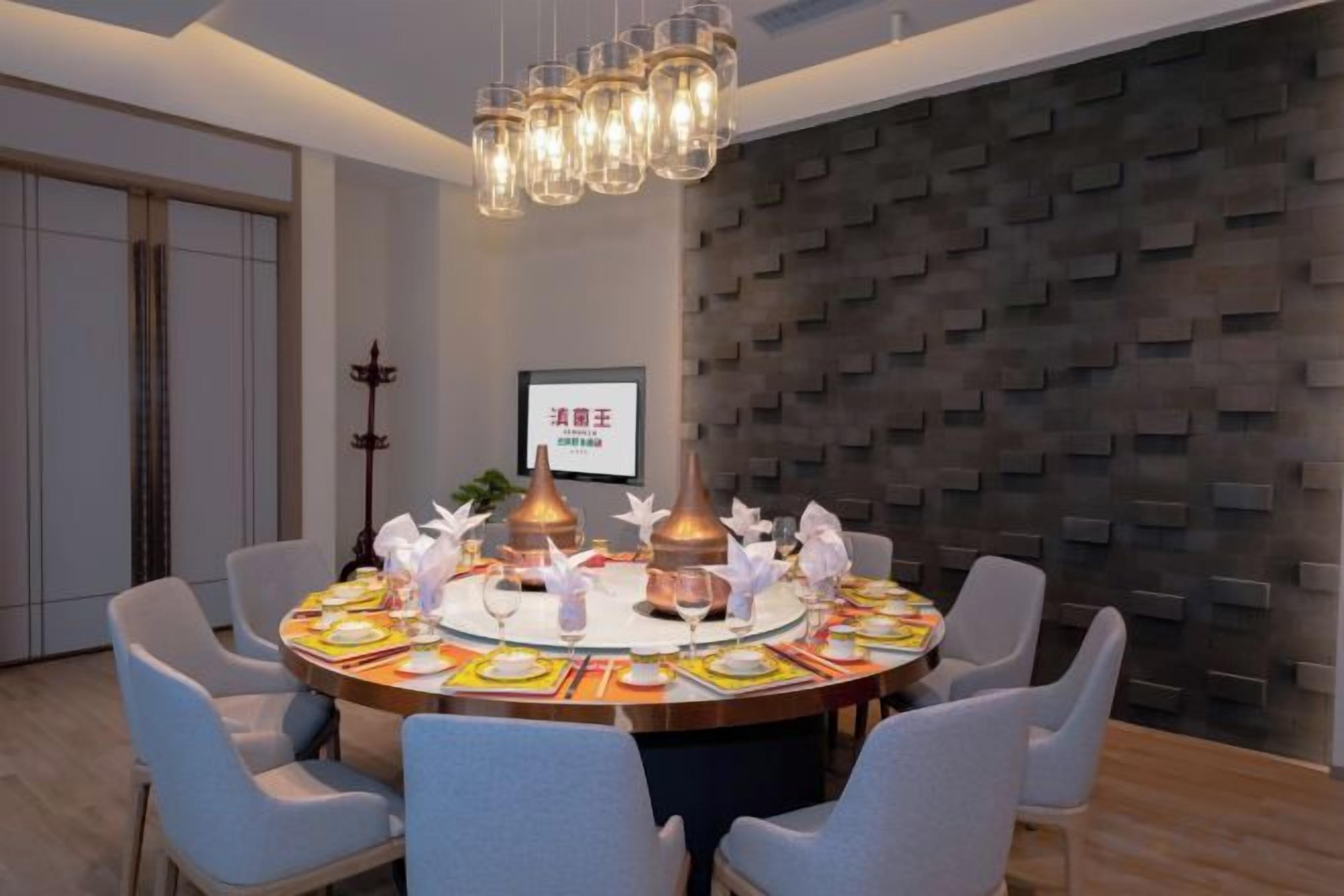 A dining area with a round table set for six, surrounded by six chairs.
