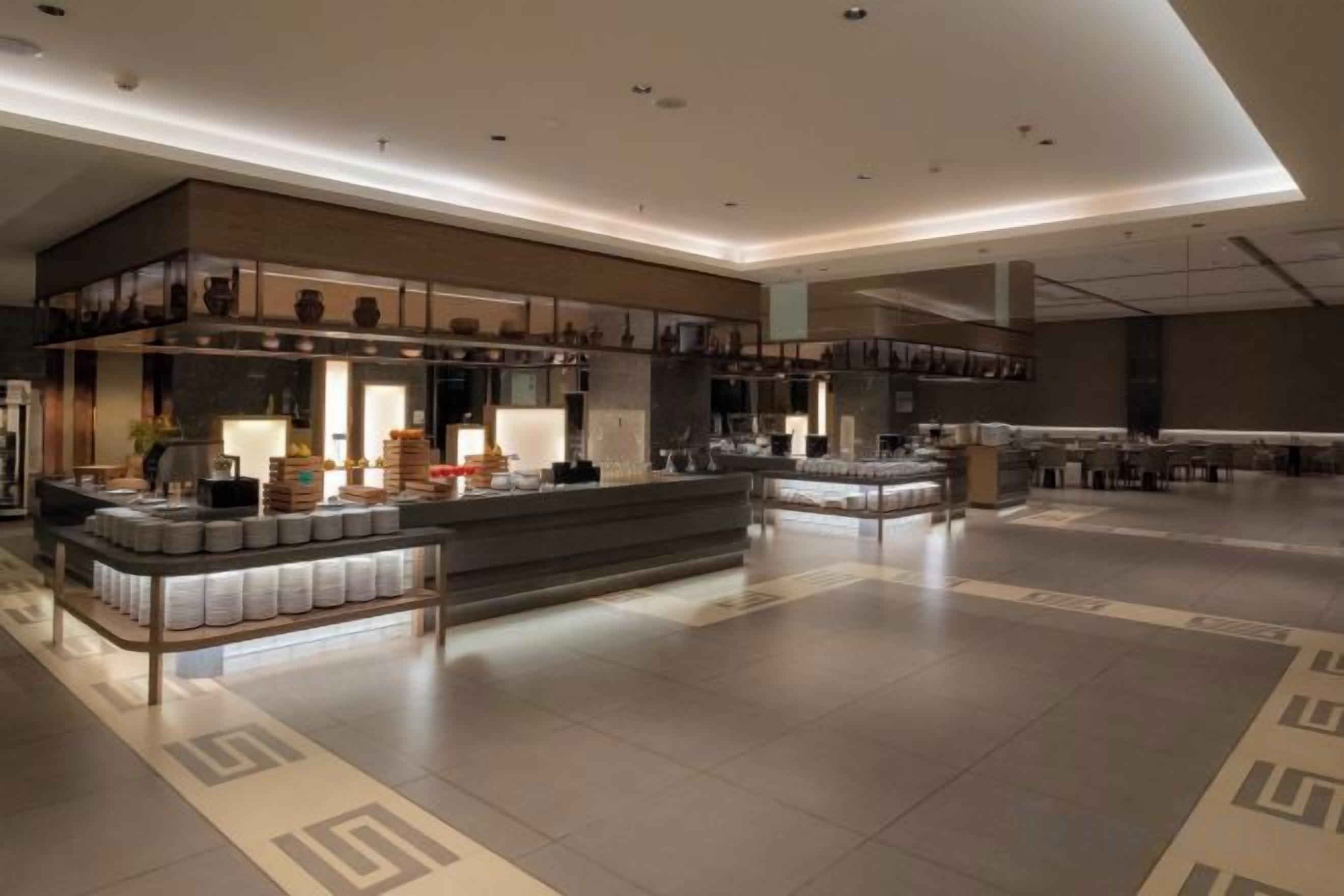 A spacious hotel lobby with a central island, seating areas, and a modern design.