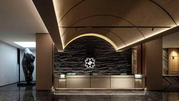 A reception area with a stone wall, a star-shaped light fixture, and a polished floor.