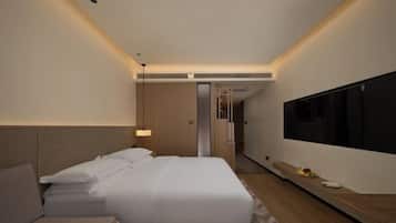 Een moderne hotelkamer met een groot bed, een televisie en een klein bureau.