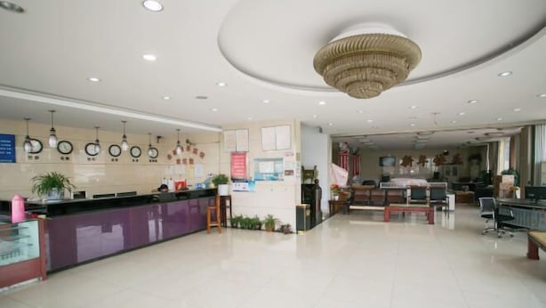 A hotel lobby with a reception desk, a chandelier, and a seating area with tables and chairs. - Shaoxing Mingdu Business Hotel (Shaoxing)