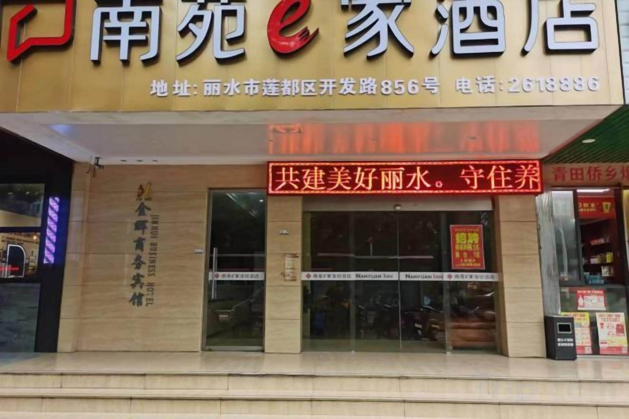 A hotel with a prominent red signboard and a visible entrance.