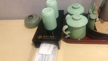 A set of green ceramic tea sets on a wooden table with a black box labeled "NANYUAN INN".