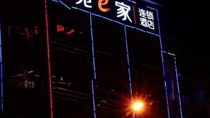 Ein Gebäude mit beleuchteter Beschilderung, darunter der Schriftzug „e 家连锁酒店“ (e Family Chain Hotel).