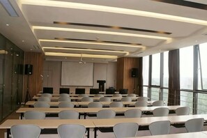 A conference room with multiple tables and chairs, a projector screen, and large windows. - Jinjiang Inn Select (Dongying Kenli Petrochemical Building) (Dongying)