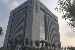 A tall, modern building with vertical lines and a glass facade.