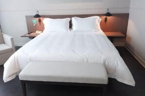 A hotel room with a large bed, bedside tables, a chair, and a bench. - Jinjiang Inn Select (Dongying Kenli Petrochemical Building) (Dongying)