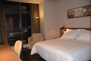 A hotel room with a large bed, a desk, a chair, and a window with curtains. - Jinjiang Inn Select (Dongying Kenli Petrochemical Building) (Dongying)