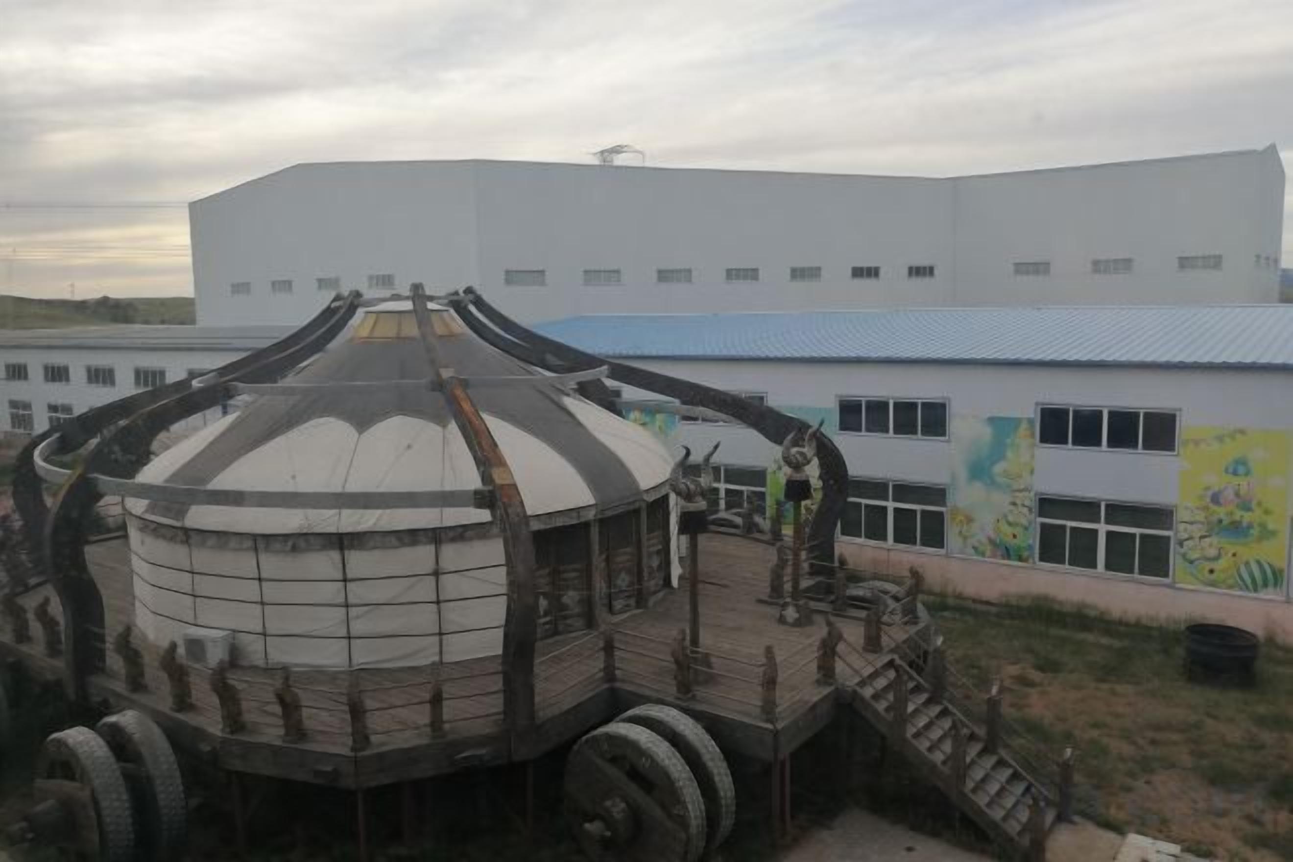 A large industrial building with a dome structure and a staircase leading to a platform.