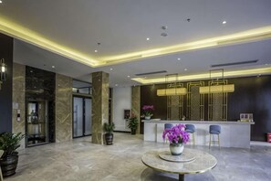 A modern lobby with a reception desk, seating area, and a marble floor. - Metropolis Hotel (Sanya Bay Coconut Dream Corridor) (Sanya)